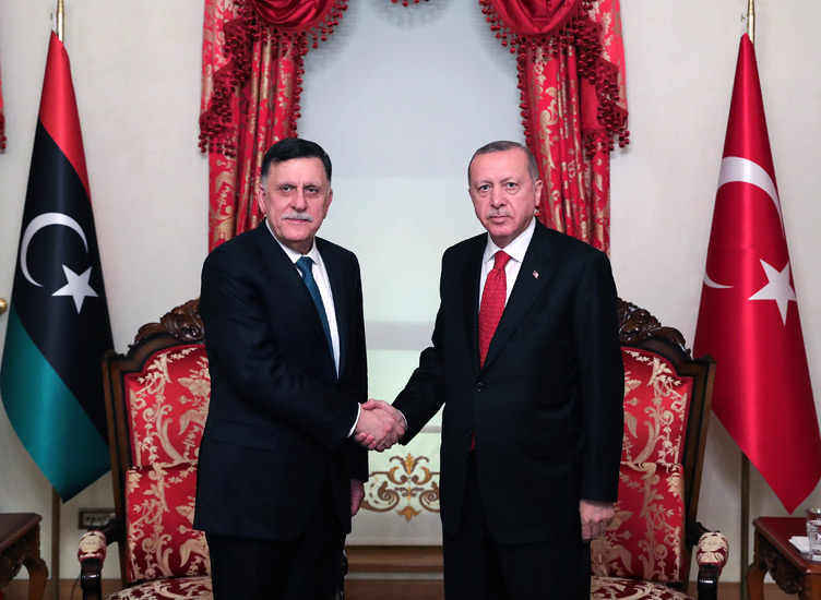 Turkish President Recep Tayyip Erdogan (R) shakes hands with Chairman of the Presidential Council of Libya Fayez al-Sarraj