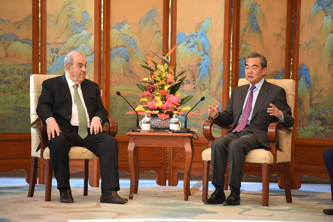 China's Foreign Minister Wang Yi talks to former Iraqi foreign minister Ayad Allawi during the Middle East Security Forum in Beijing