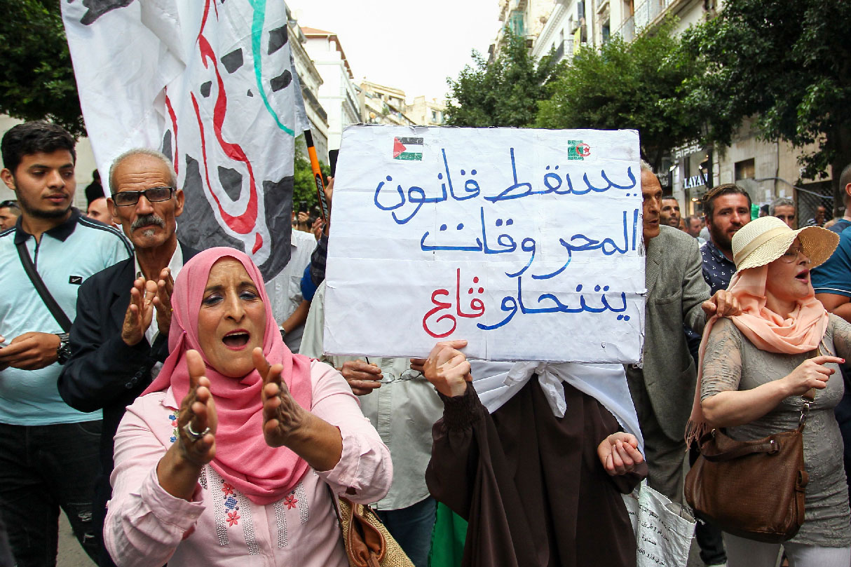 Algerian demonstrators hold a placard that reads in Arabic "down with the hydrocarbons law" in Algiers