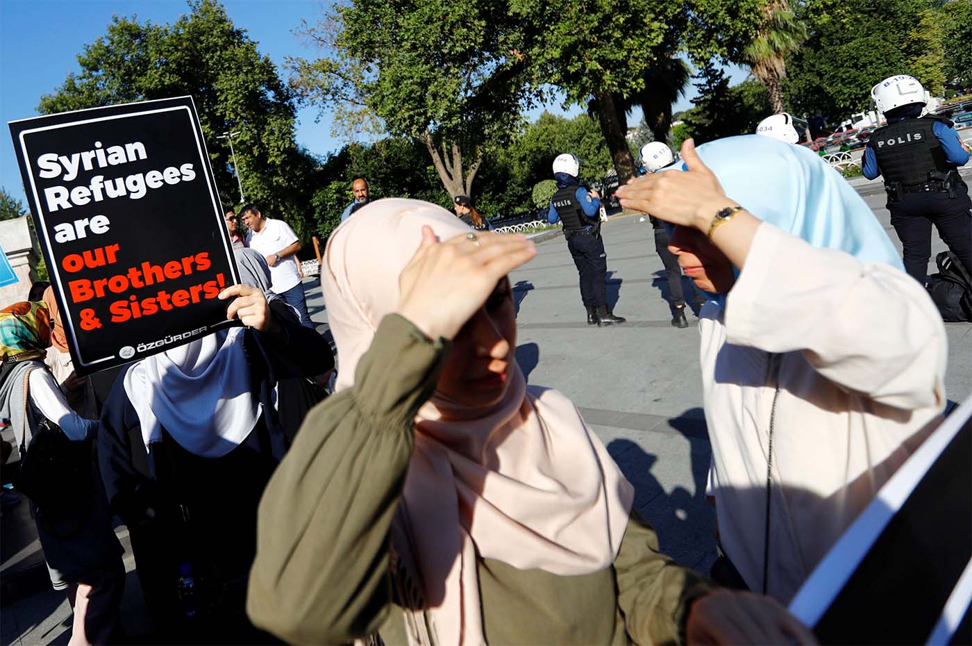 A demonstrator holds a placard in support of Syrian in Istanbul during a protest against Turkish government's recent refugee policies in Istanbul