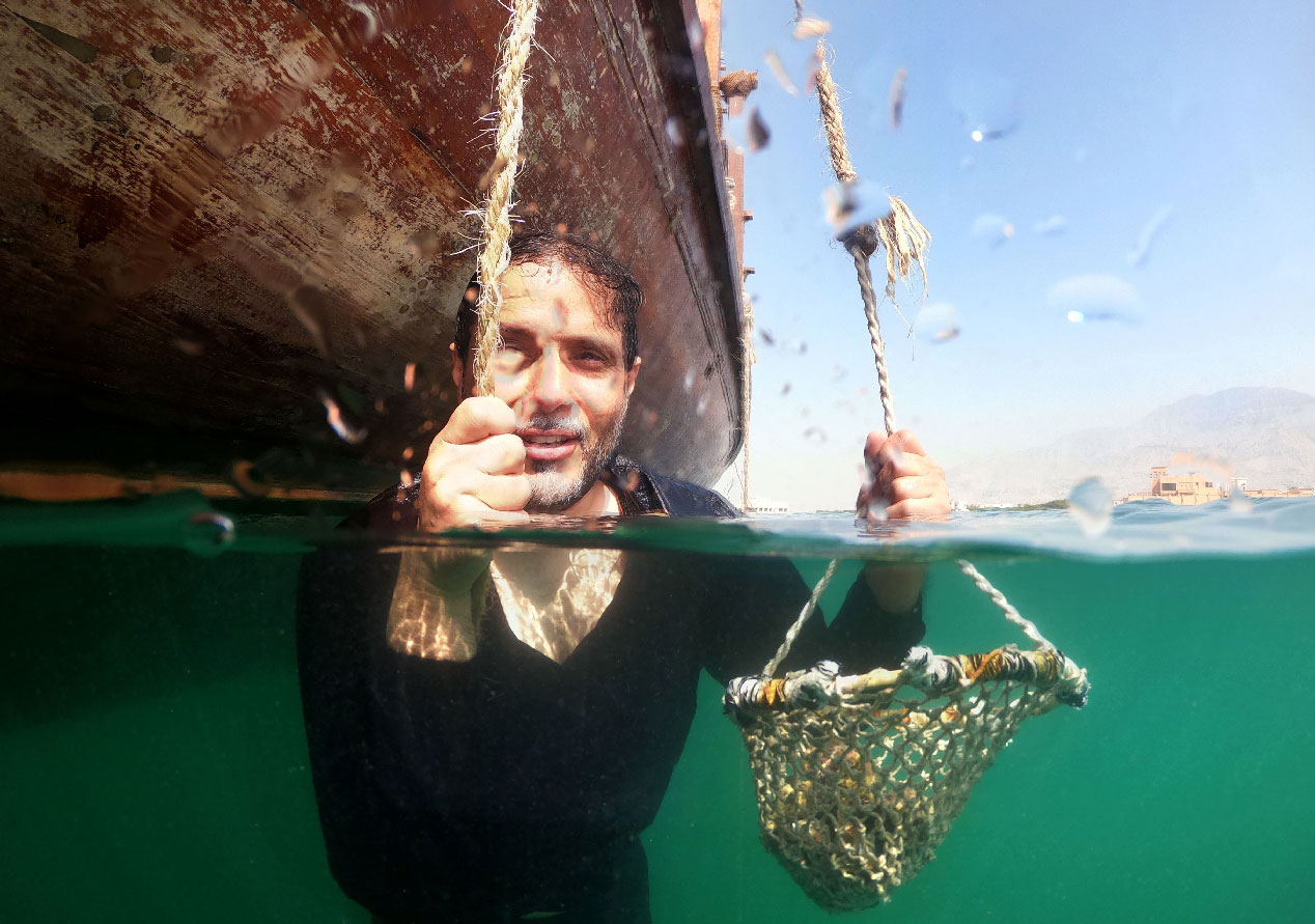 Emirati Abdullah al-Suwaidi demonstrates how his ancestors would pick up oysters off the seabed