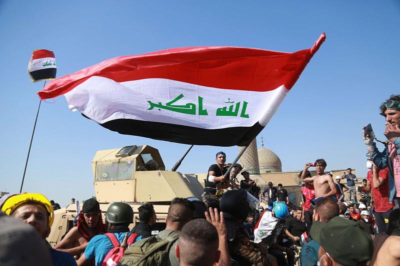 Anti-government protesters try to cross the al- Shuhada (Martyrs) bridge in central Baghdad