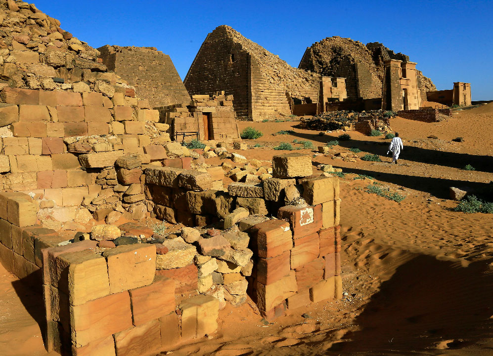 A man walks past the Royal Cemeteries of Meroe Pyramids in Begrawiya