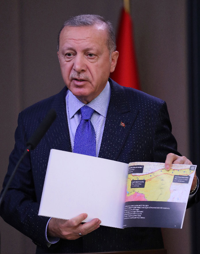 Turkish President Recep Tayyip Erdogan shows a document with a map of Turkey-Syria border 