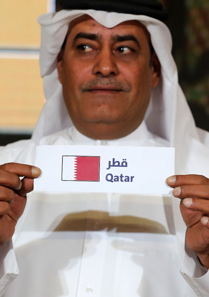 Hamed al-Hajri, a member of the Qatar Football Association, holds up the name of Qatar during the group draw for the 24th Arabian Gulf Cup