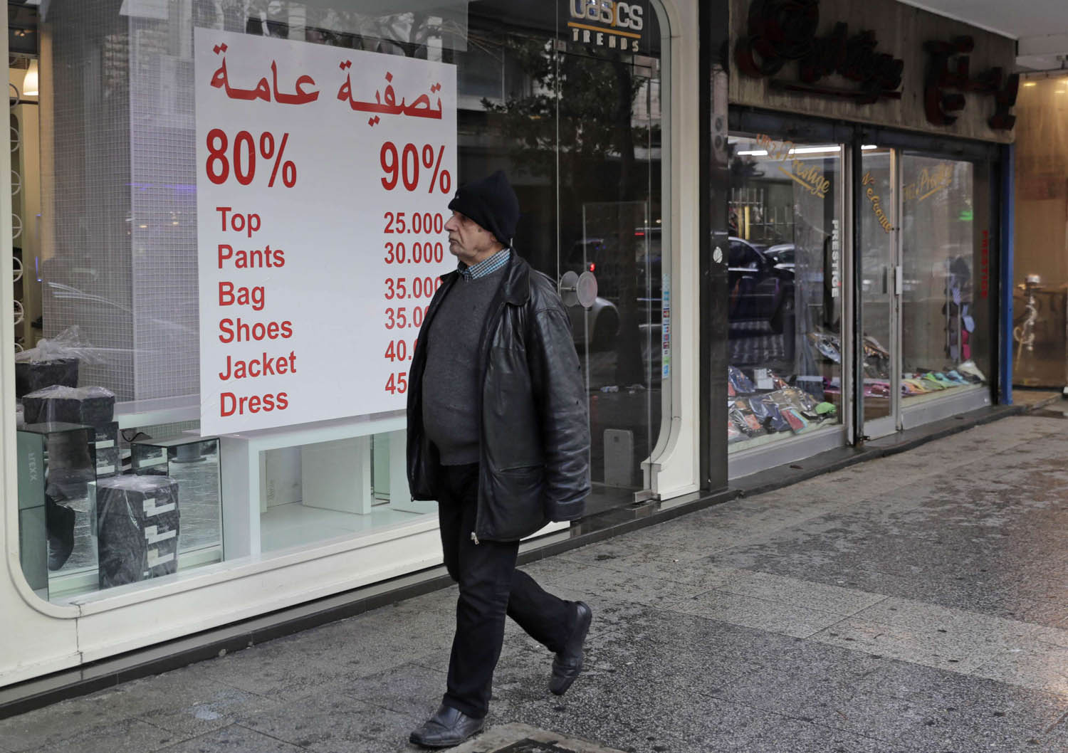 لبناني يمر بجانب محل يعرض تنزيلات وسط بيروت