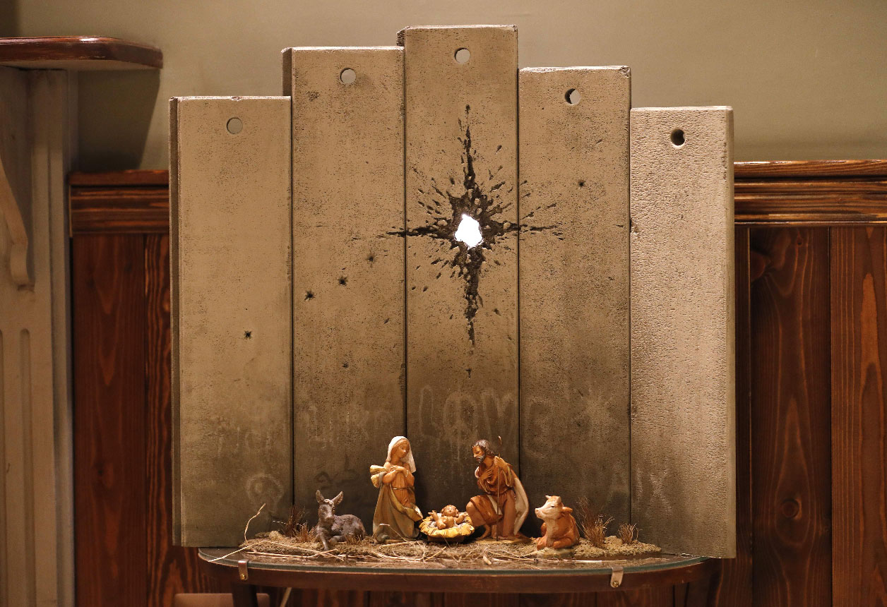 A new Christmas-themed artwork dubbed the "Scar of Bethlehem" by secretive British artist Banksy is displayed at his Walled-Off Hotel in Bethlehem