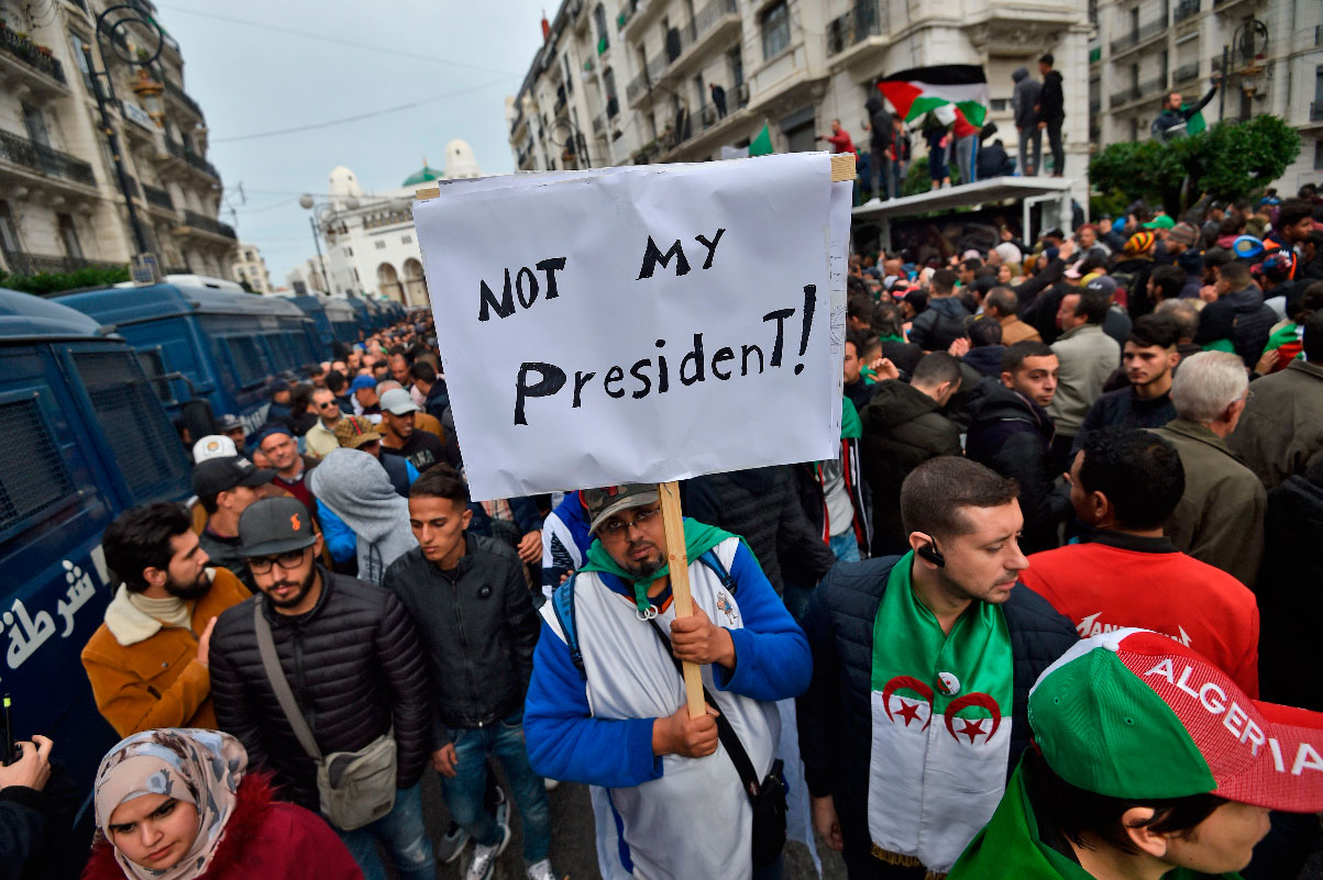 An Algerian protester lifts a placard in the capital Algiers