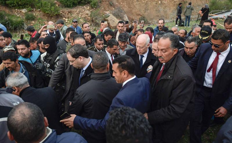 Tunisian President Kais Saied (C-R) and Prime Minister Youssef Chahed (C-L) visit the scene of a road accident in which a bus plunged over a cliff in Ain Snoussi in north-western Tunisia