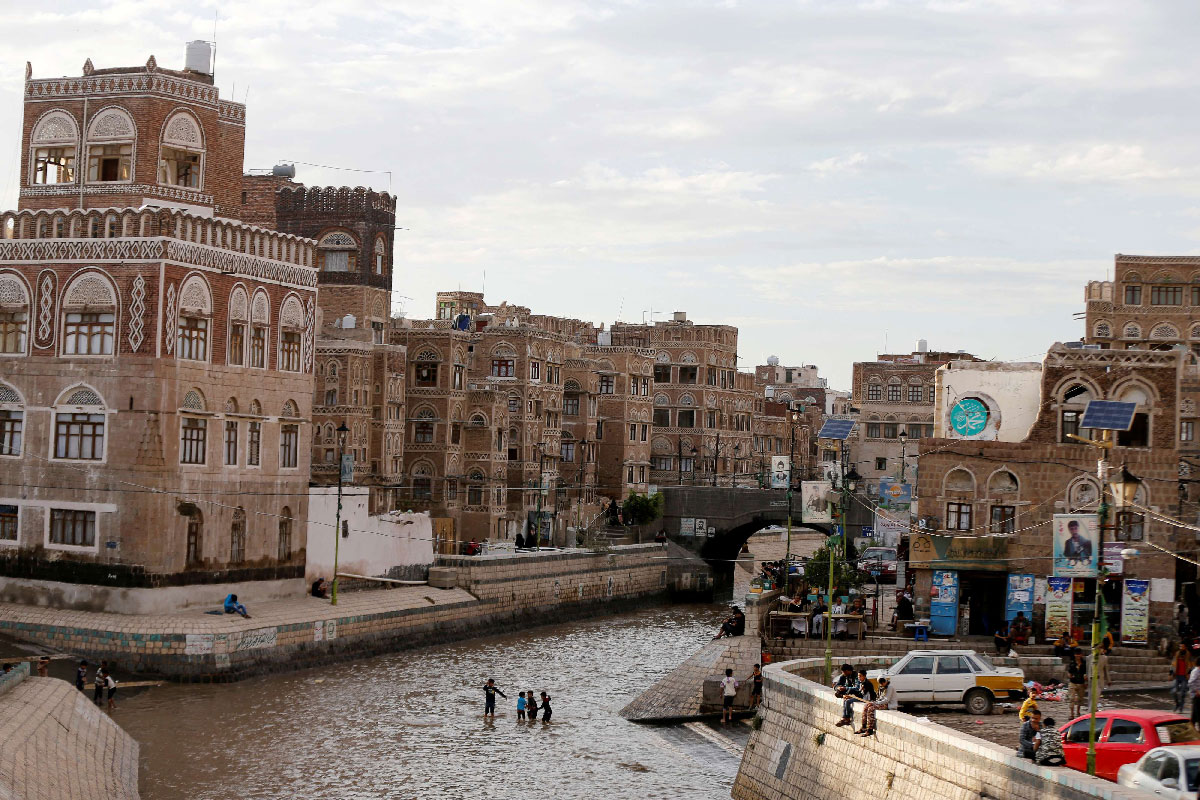 Boys play on a floodway following heavy rains in the old quarter of Sanaa