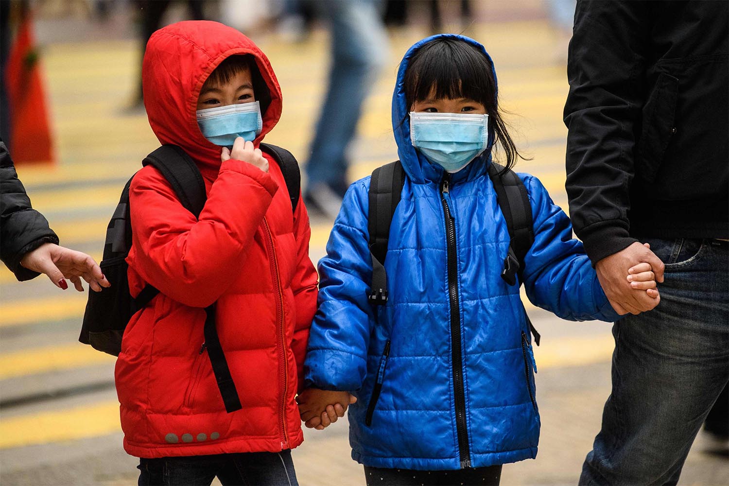 hildren wearing face masks cross a road during a Lunar New Year of the Rat public holiday in Hong Kong