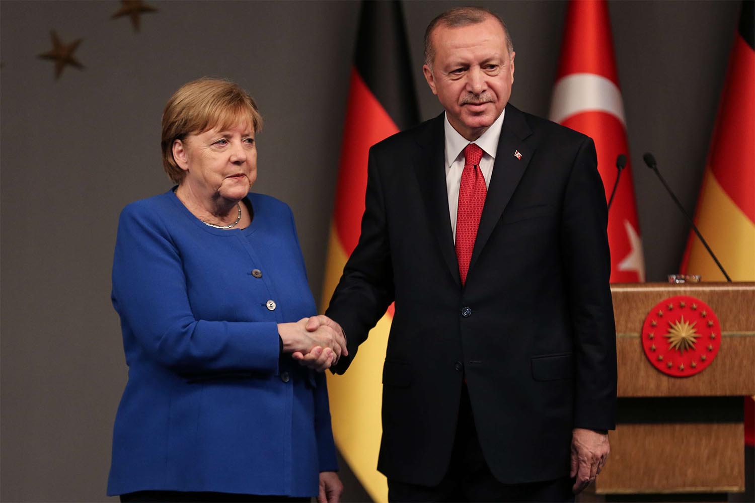 Turkish President Recep Tayyip Erdogan and German Chancellor Angela Merkel shake hands after a mutual press conference