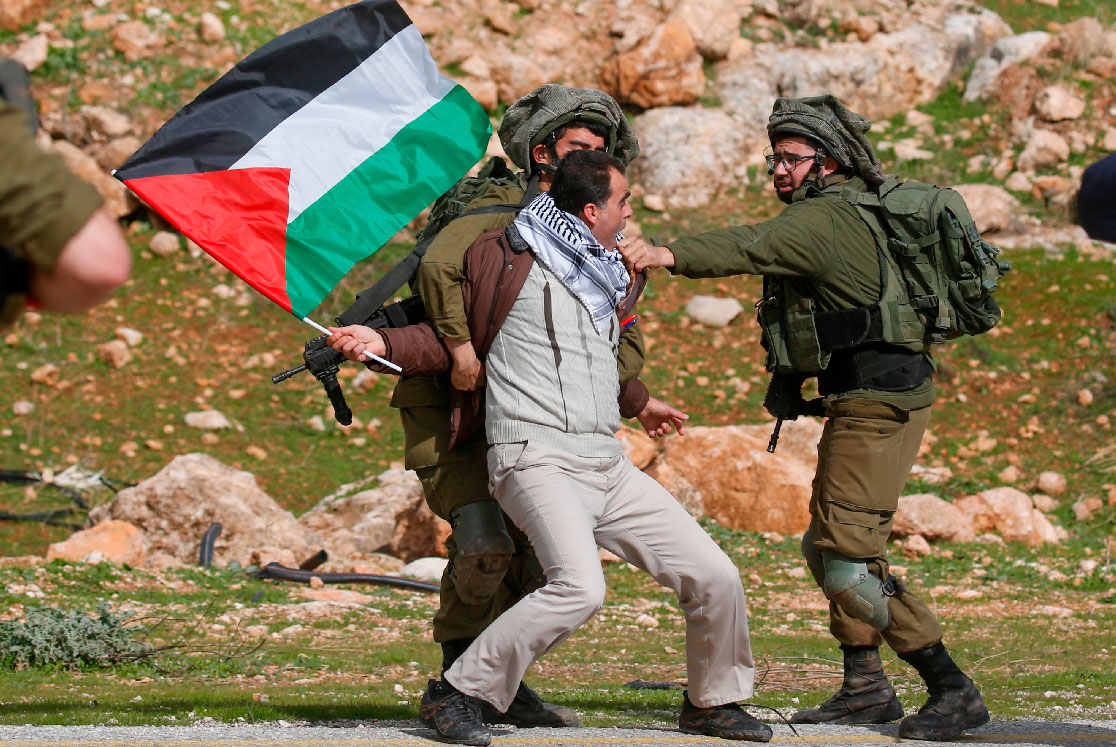 A Palestinian demonstrators is detained by Israeli soldiers during a demonstration near the West Bank village of Tubas