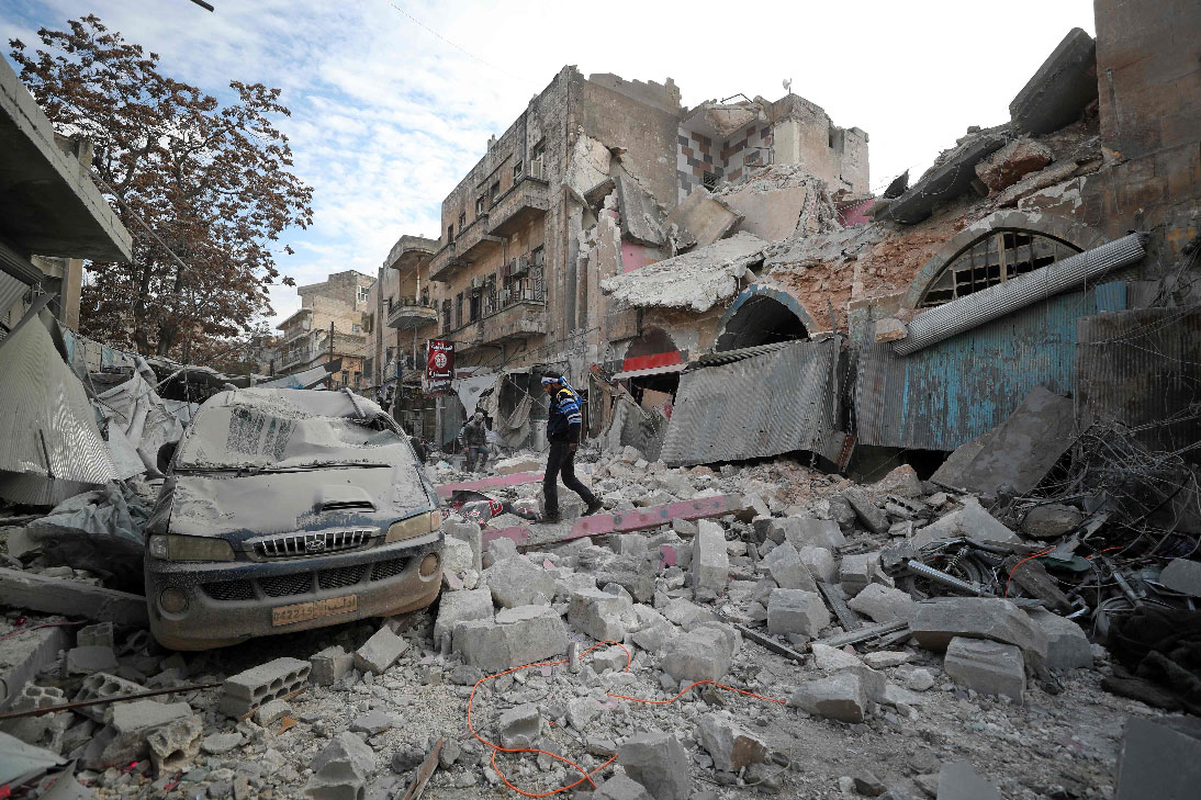 A Syrian walks on the rubble of a building following a regime air strike
