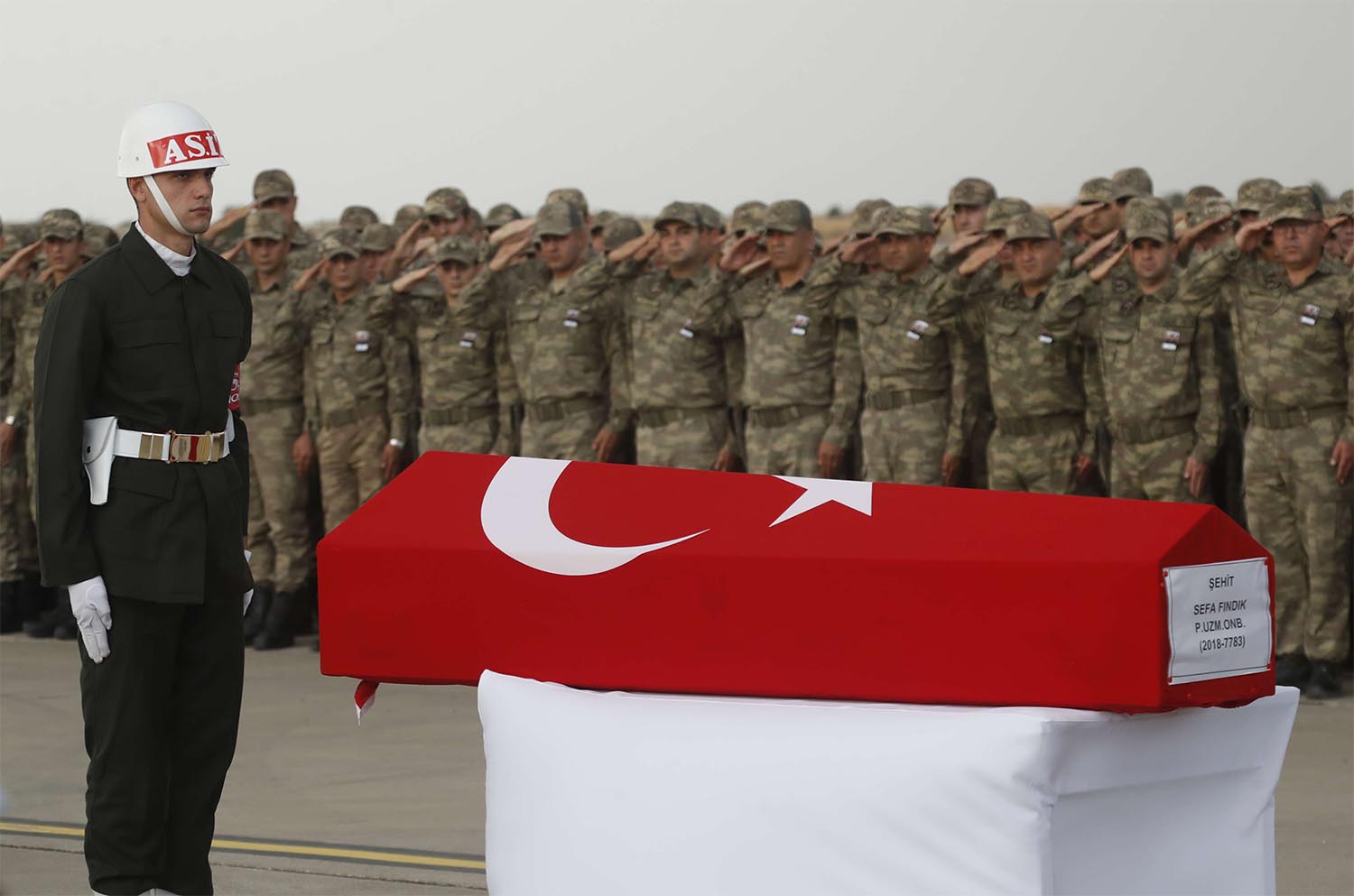 Turkish soldiers salute the Turkish flag-draped coffin of soldier Sefa Findik, killed in action in Syria last October