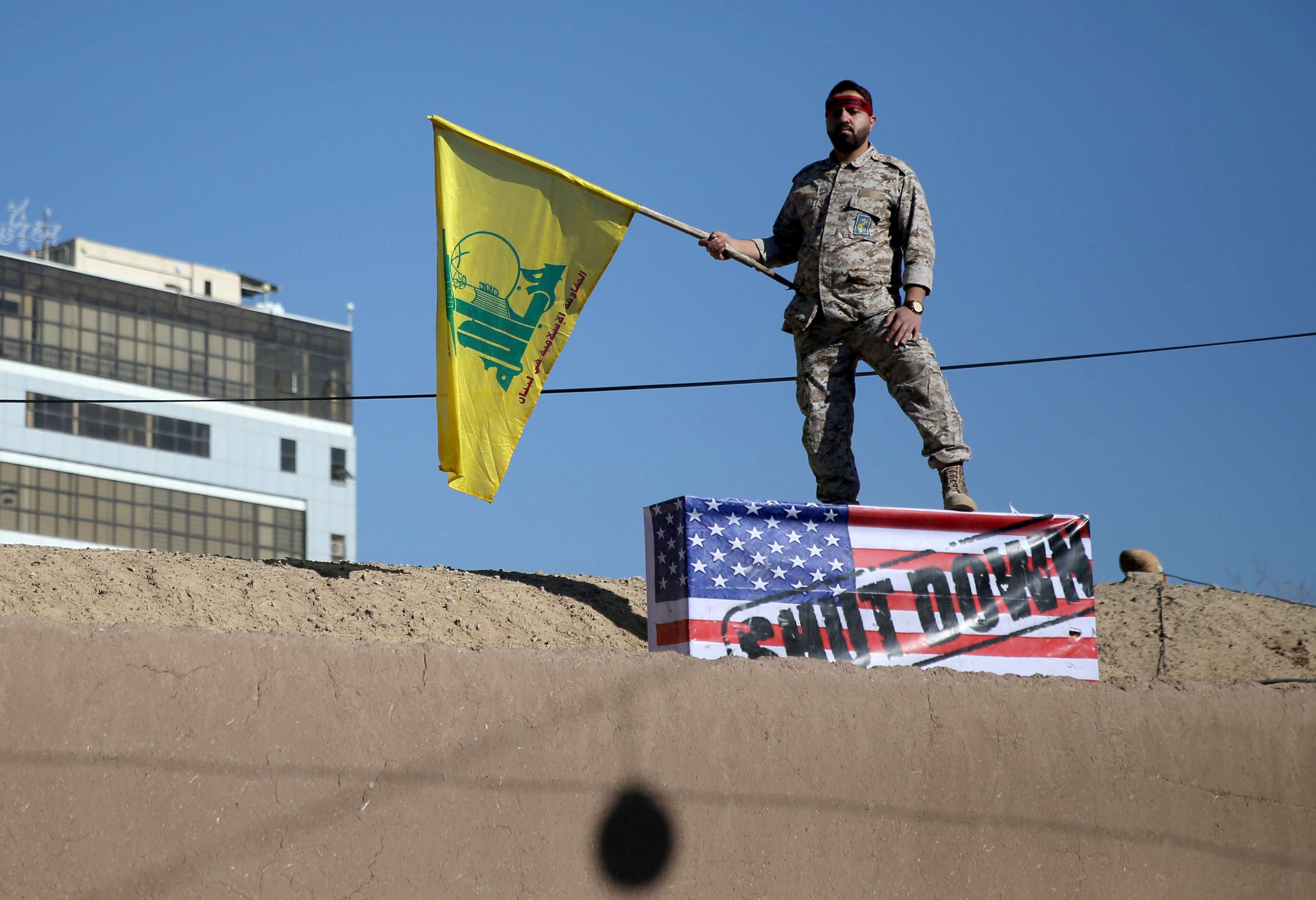 An Iranian guard holds a Hezbollah flag