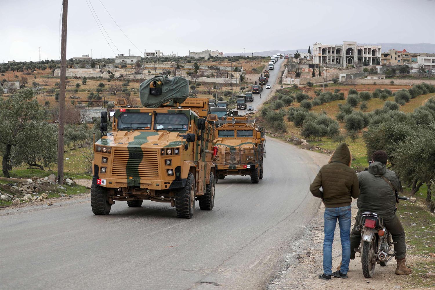 A Turkish military convoy of tanks and armoured vehicles passes near the city of Idlib