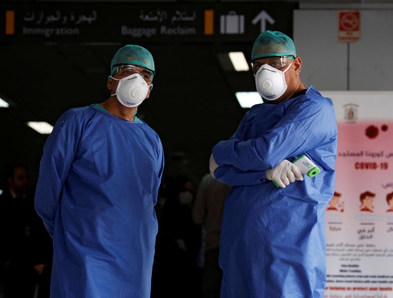 Health officials wait to test passengers as part of security measures to avoid coronavirus in the country, at Damascus international airport