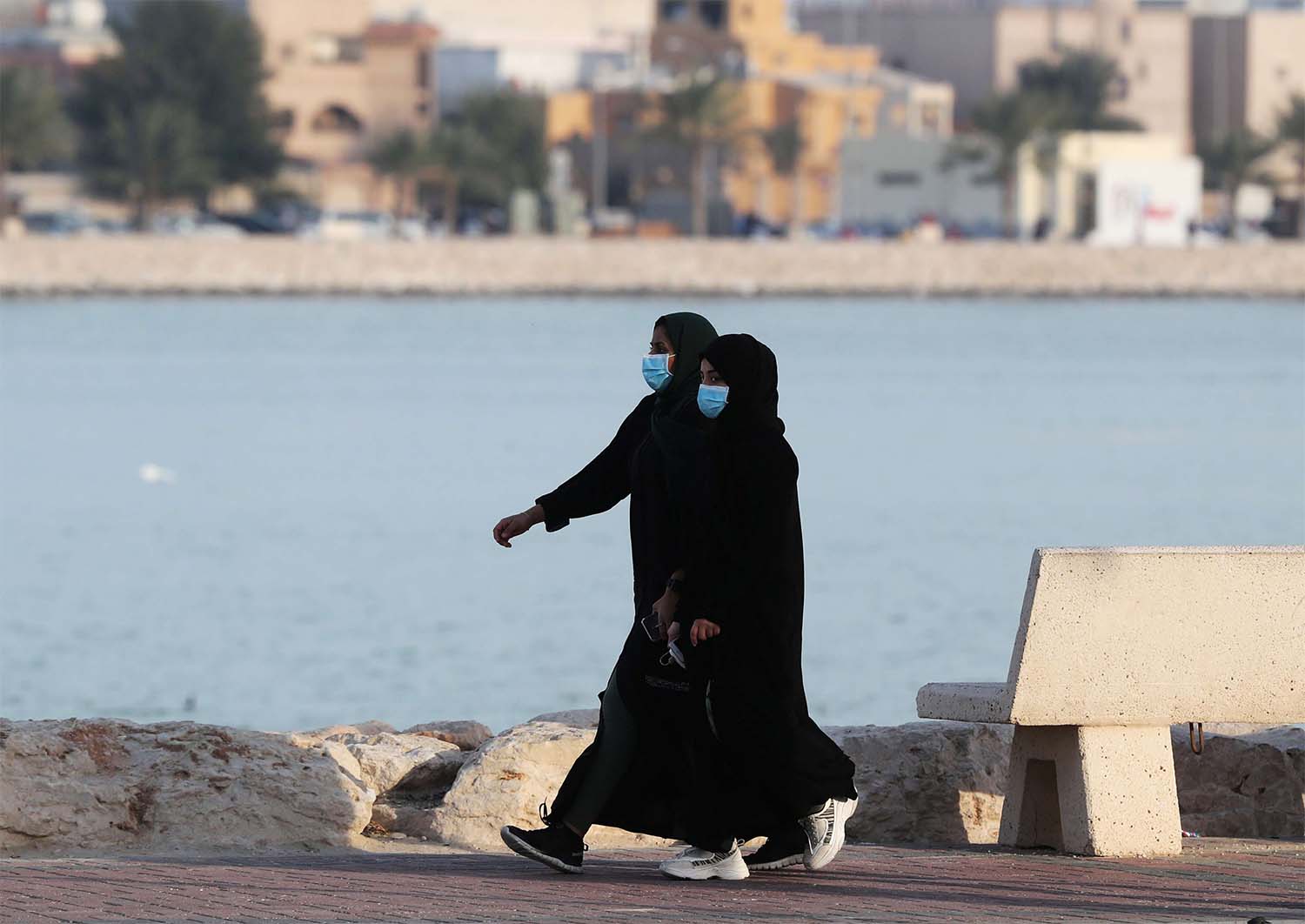 Women wear protective face masks, as they walk, after Saudi Arabia imposed a temporary lockdown on the province of Qatif
