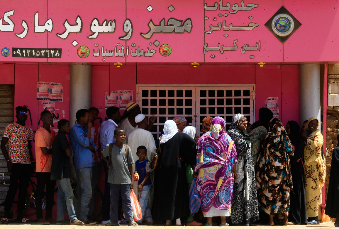 Sudanese people queue up outside a bakery in Omdurman