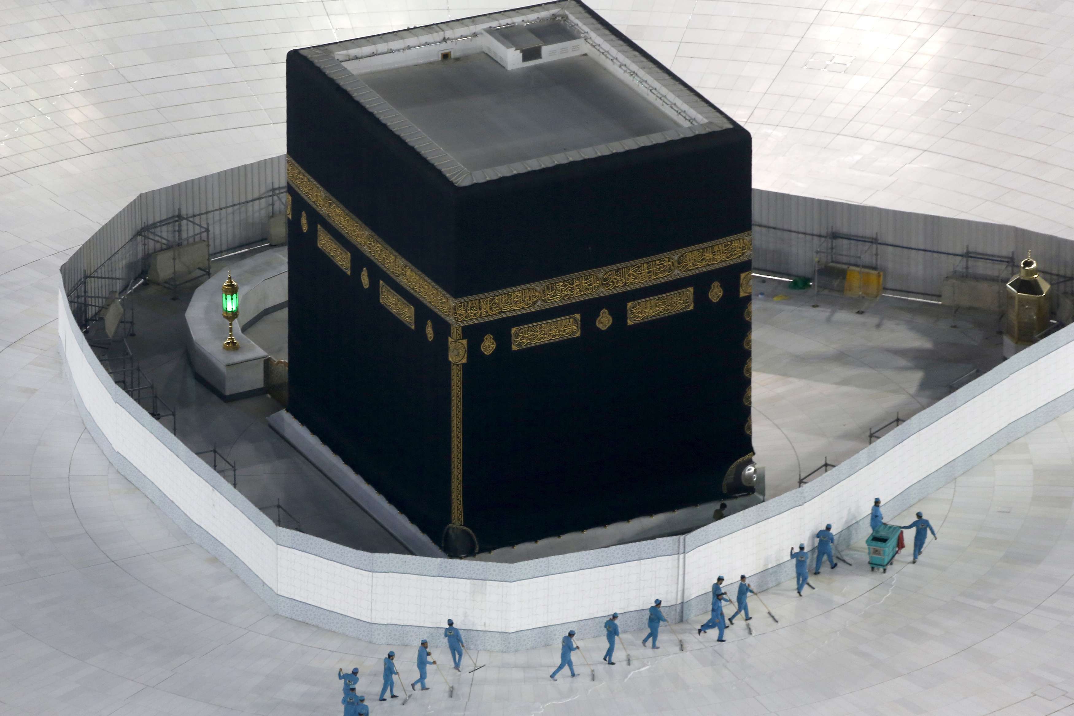 Workers disinfect the ground around the Kaaba in Mecca