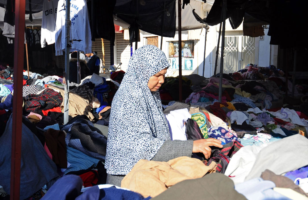 A Tunisian woman looks at clothes at a market in Tunis