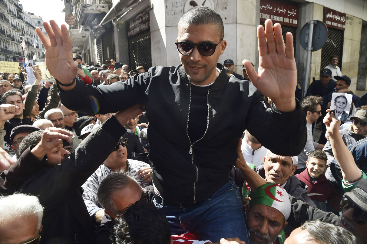 Algerian protesters carrying journalist Khaled Drareni on their shoulders