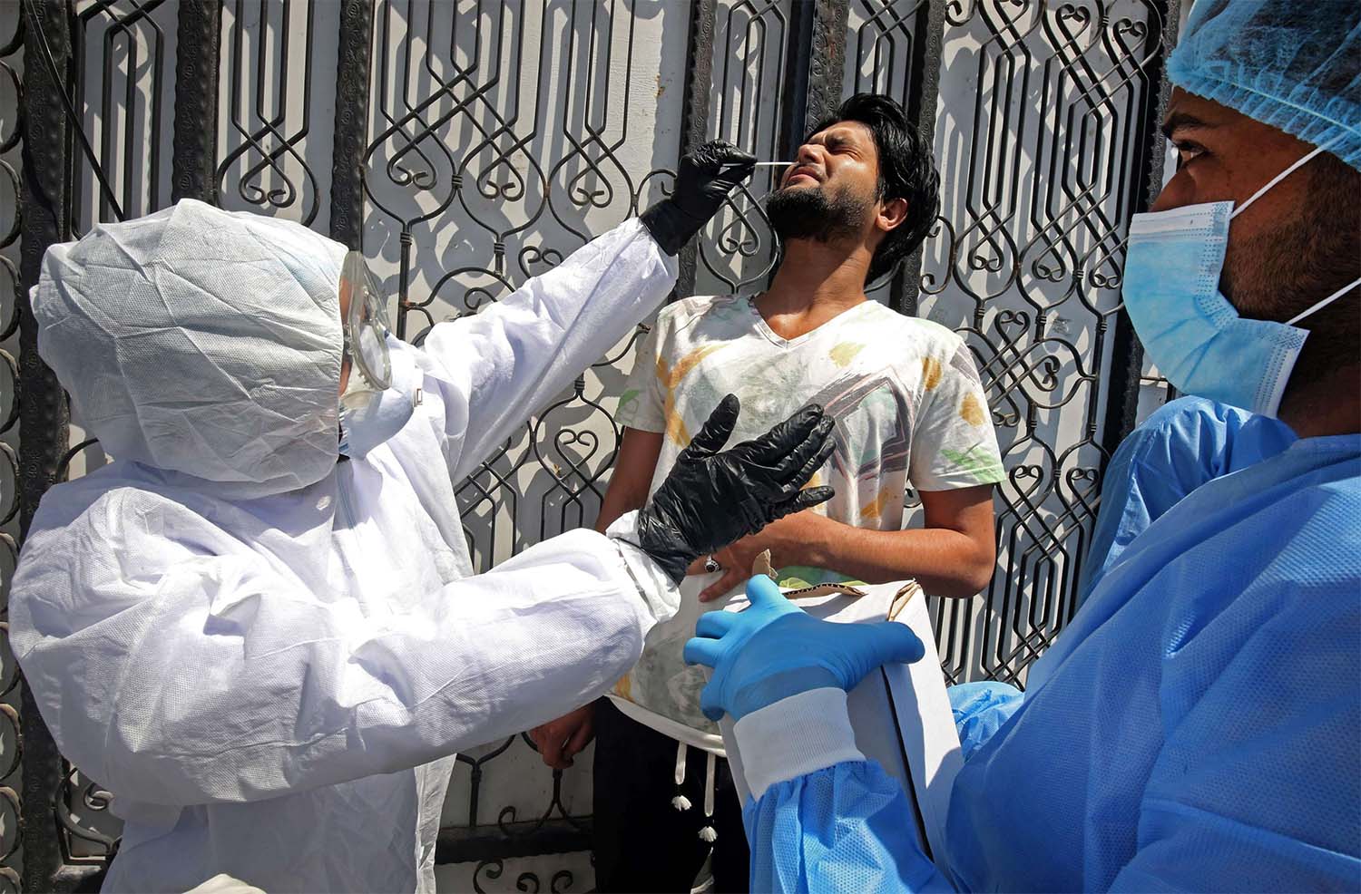 Iraqi public hospital specialised doctors test a resident for COVID-19 in the capital Baghdad's suburb of Sadr City