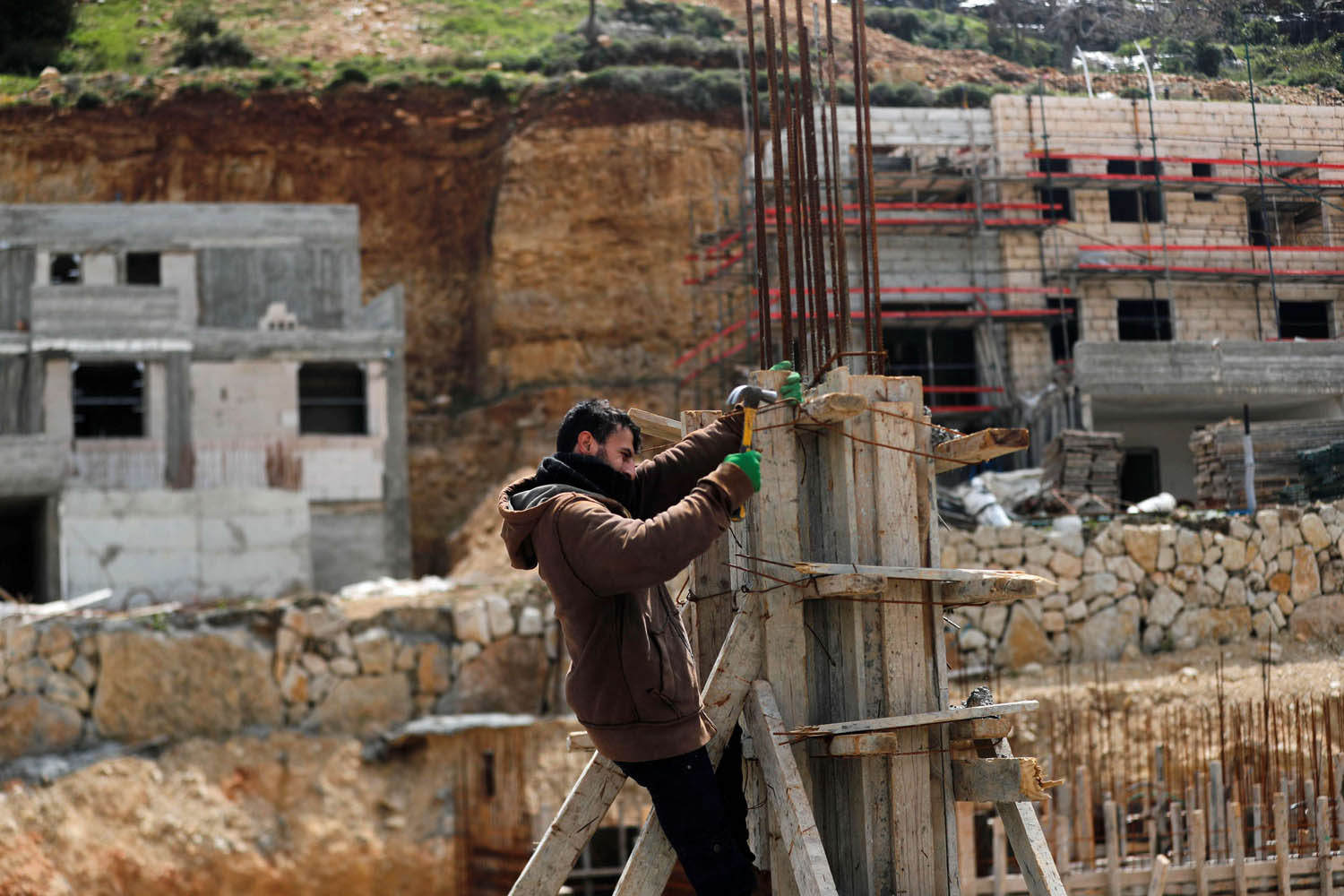 فلسطيني يعمل في بناء مستوطنة اسرائيلية في الضفة الغربية