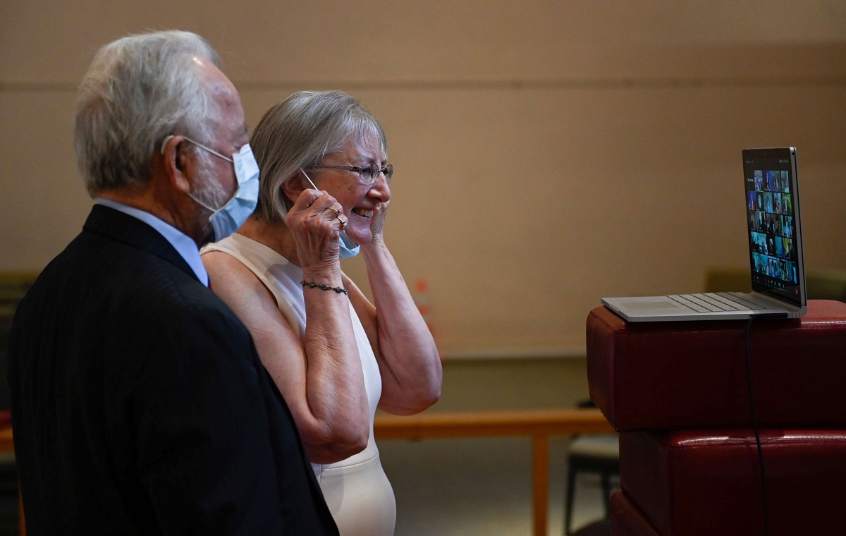 زوجان أميركيان يتحدثان مع أقاربهما عبر تطبيق زوم بعد حفل زفافهما في كنيسة بفرجينيا