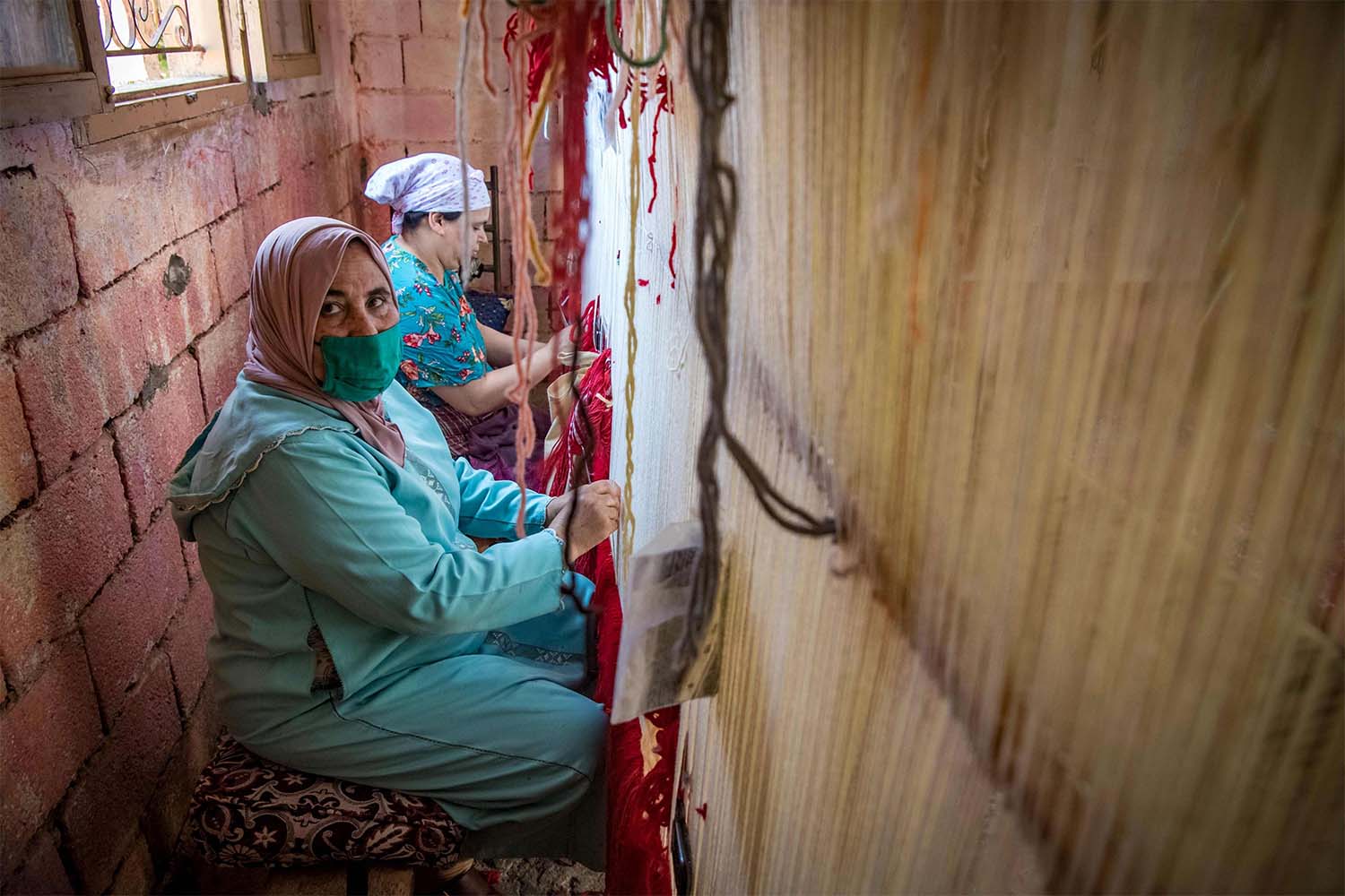 Moroccan rug weavers create a carpet at a workshop in the city of Sale