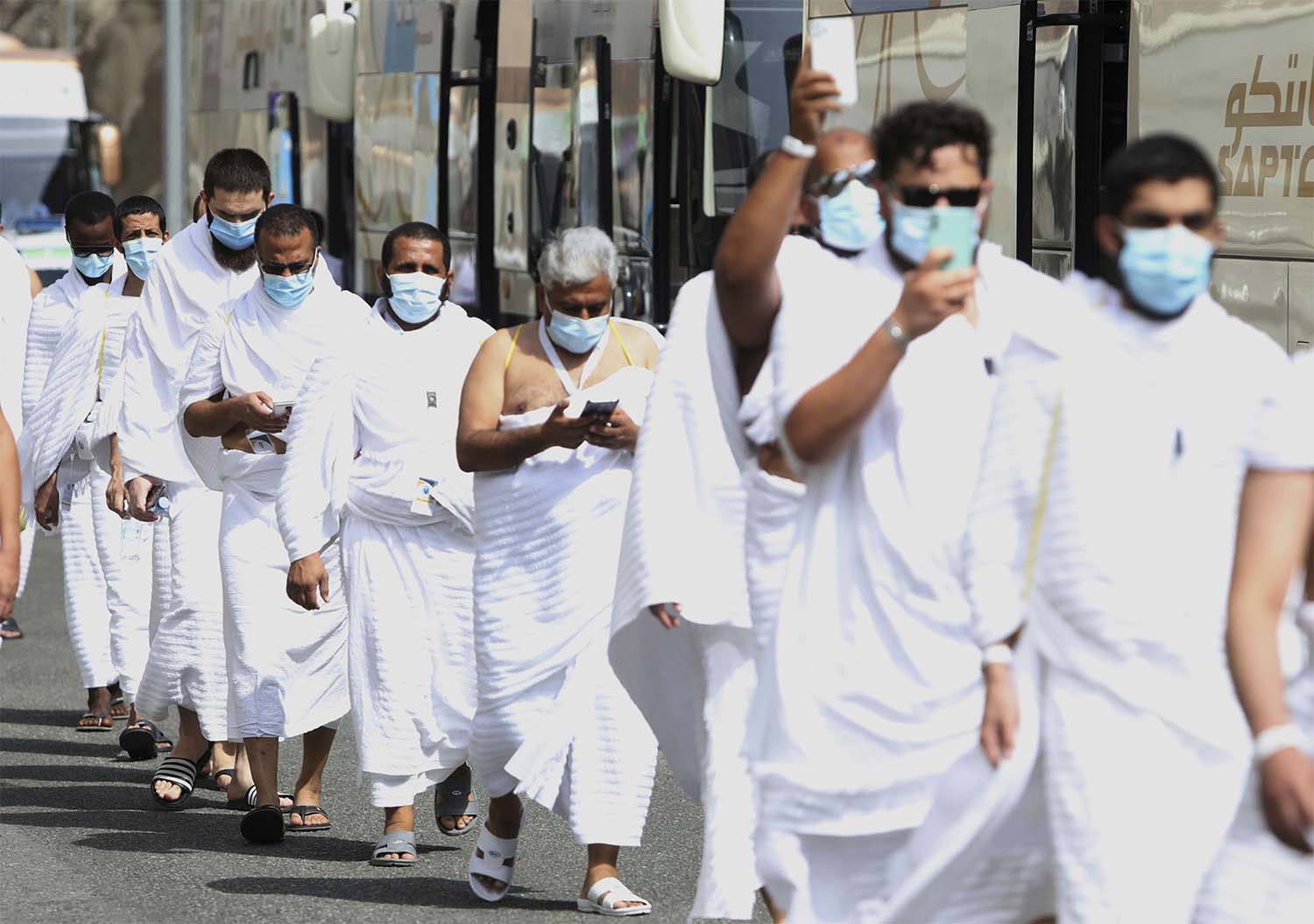 Muslim pilgrims enter Namira Mosque in Arafat, as they wear masks and keep social distance to protect themselves against coronavirus