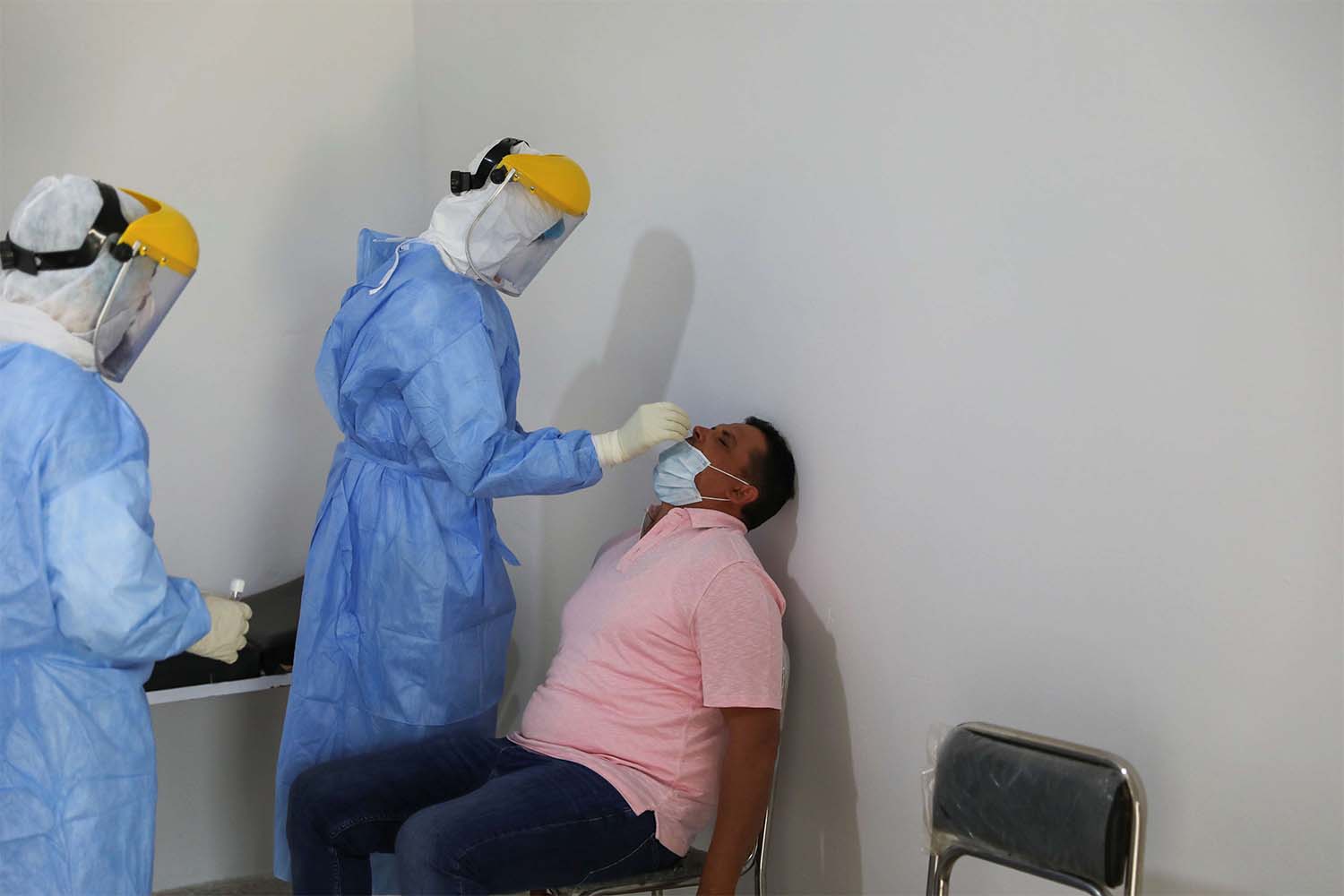 A member of a medical team takes a swab to test for the coronavirus disease