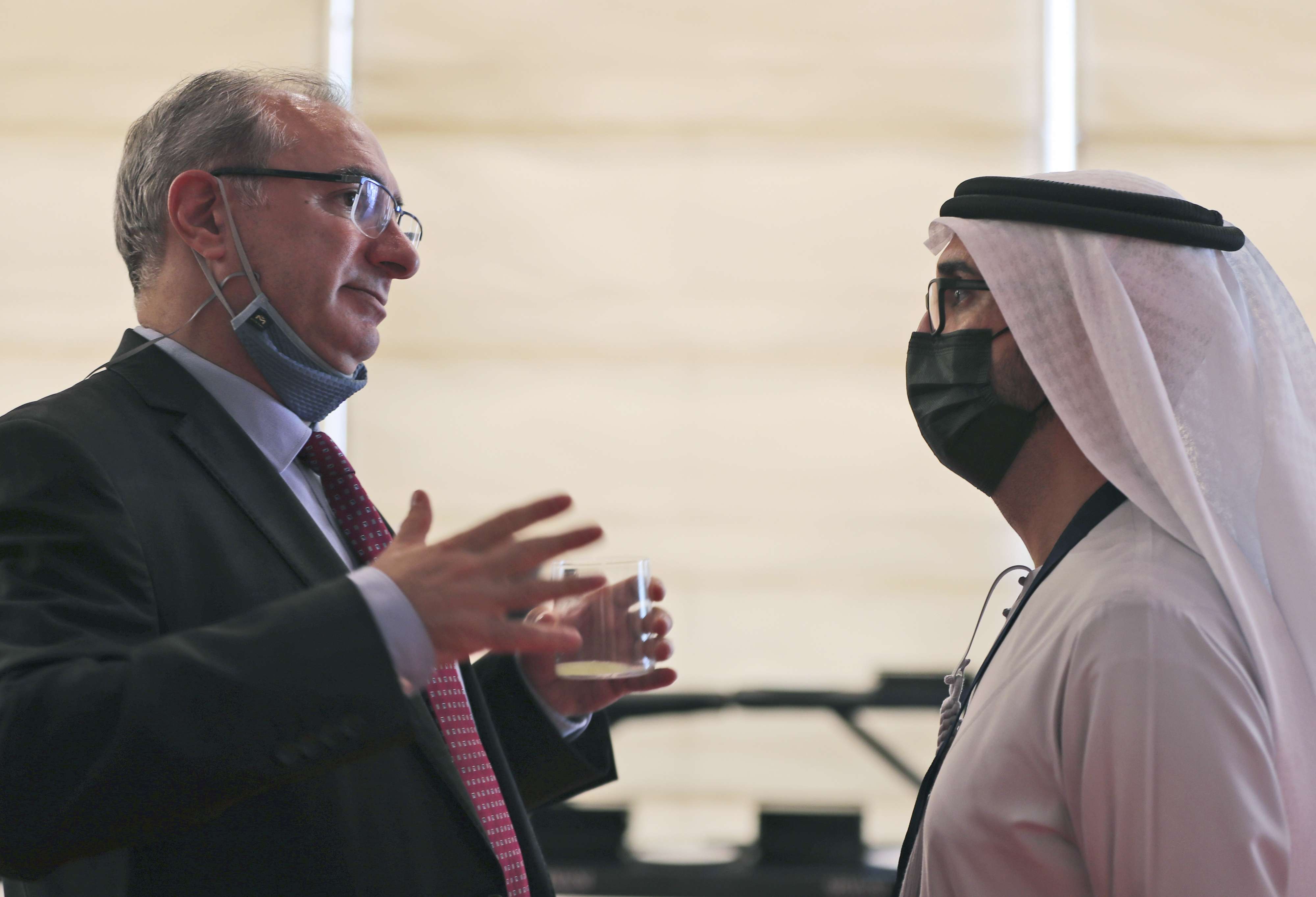 سفير إسرائيل في الإمارات إيتان نائيه (يسار) يتحدث مع مسؤول إماراتي خلال منتدى الاستثمار العالمي في دبي 