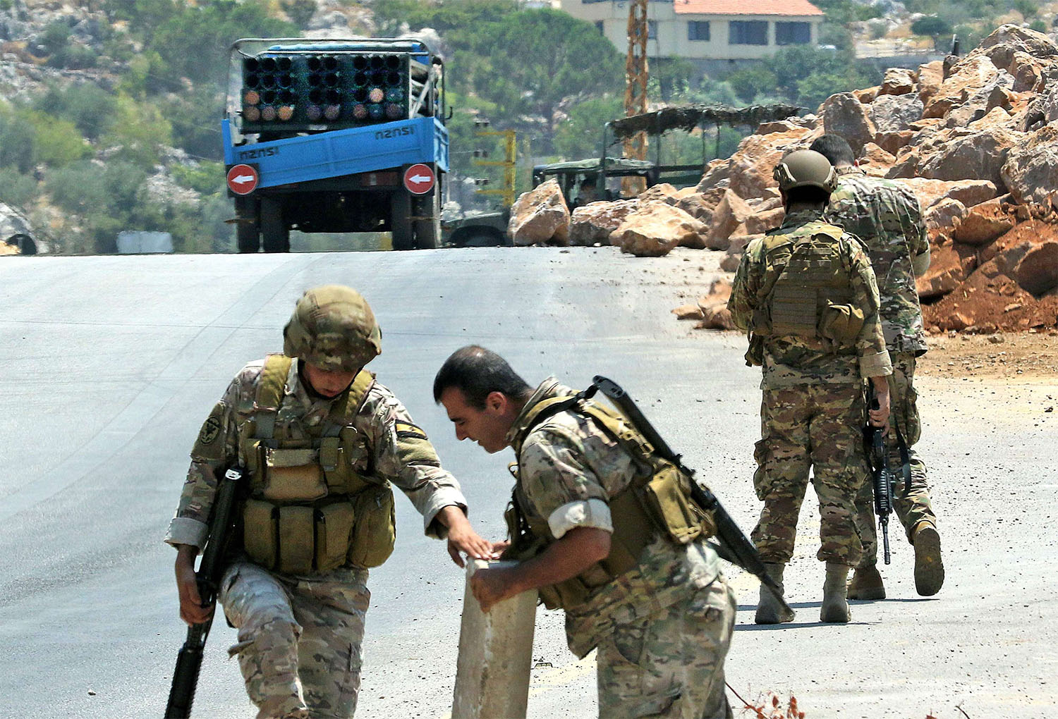 Lebanese soldiers stand next to a a truck carrying a multiple rocket launcher after confiscating it