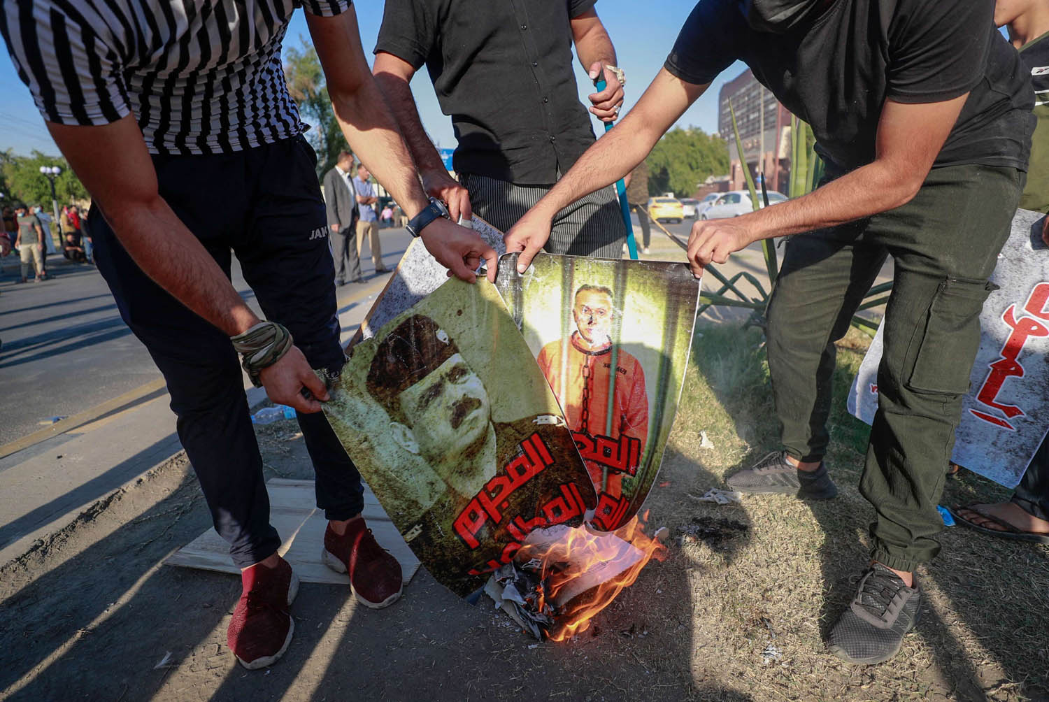 متظاهرون من الحشد الشعبي يحرقون صورا للكاظمي وقادة عسكريين عراقيين
