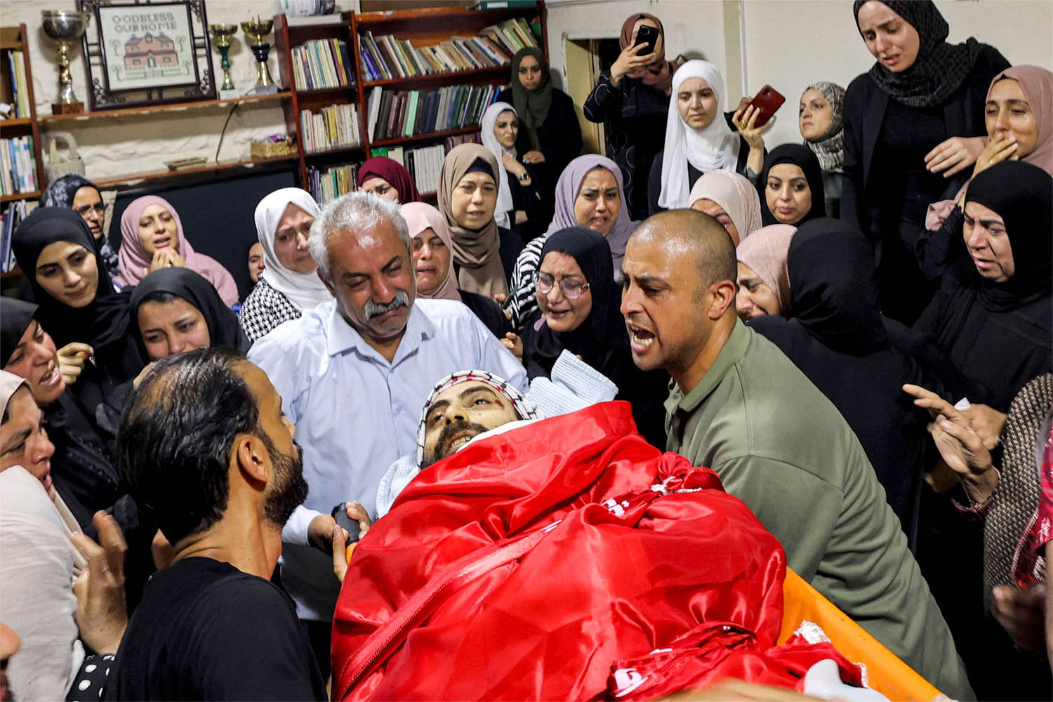 Relatives mourn by the body of Palestinian Ali Harb