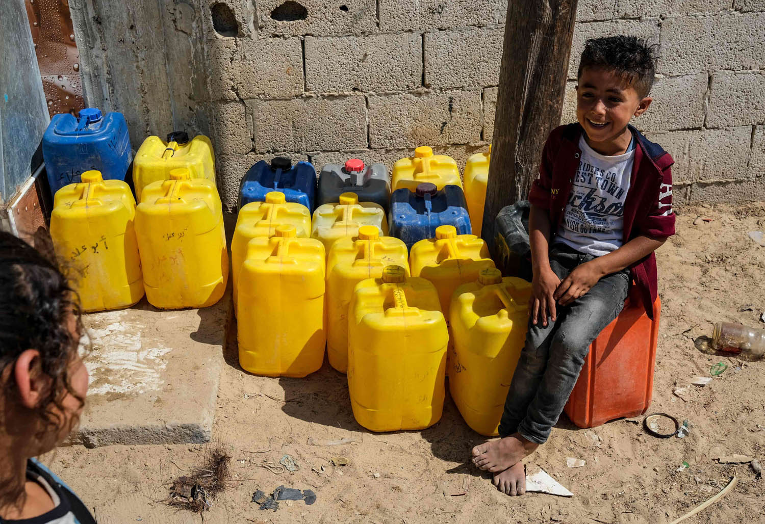 أطفال فلسطينيون ينتظرون توزيع الماء في رفح