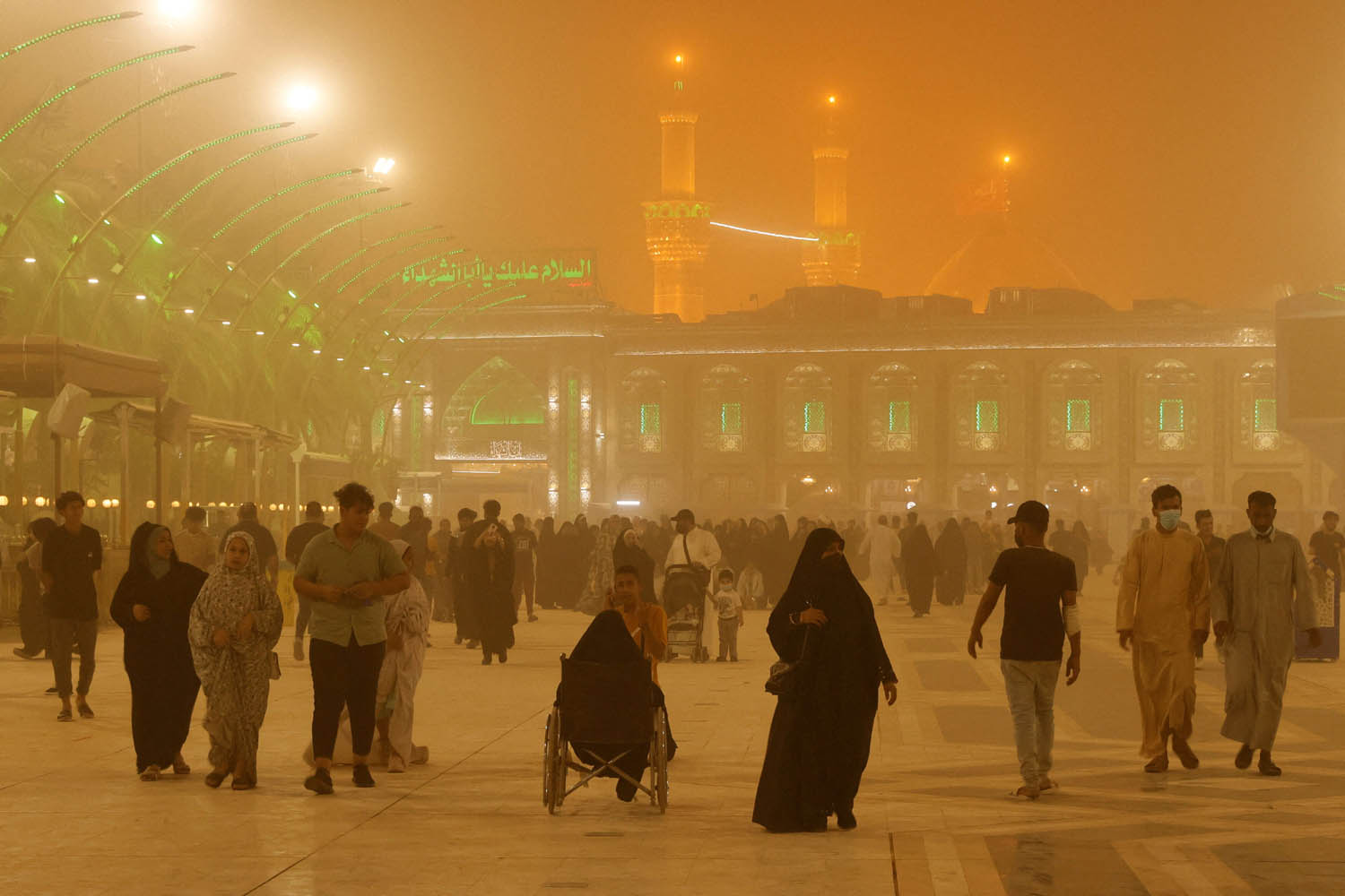 زوار عراقيون لضريح الإمام الحسين في كربلاء أثناء عاصفة ترابية