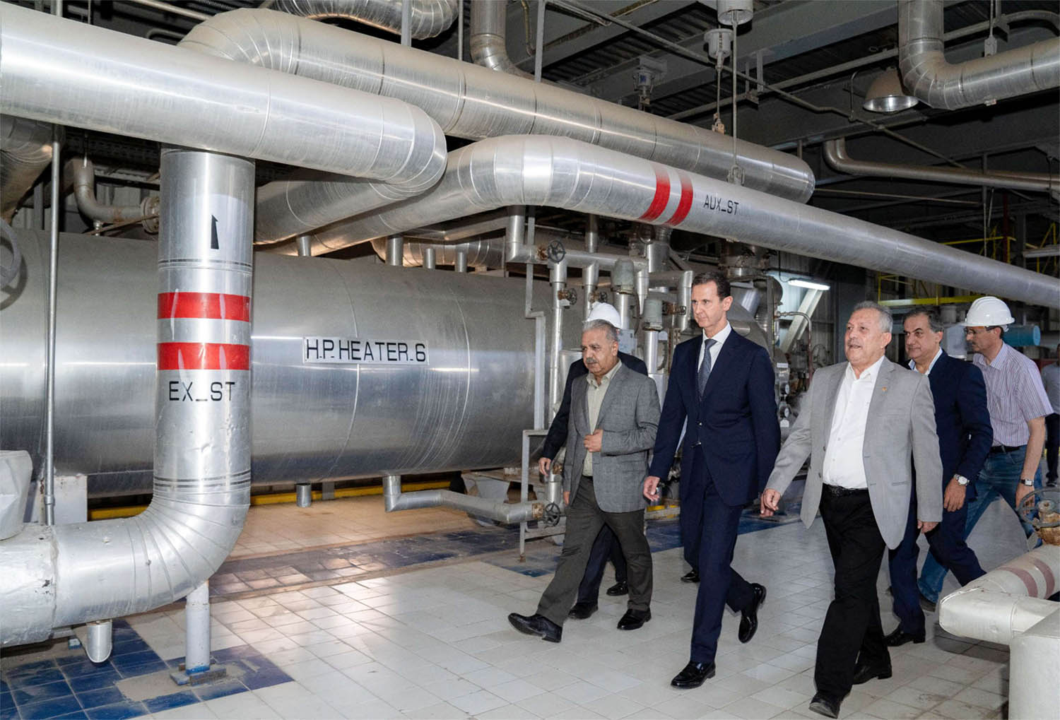 Assad (C) touring a thermal power station in the eastern countryside of Aleppo province