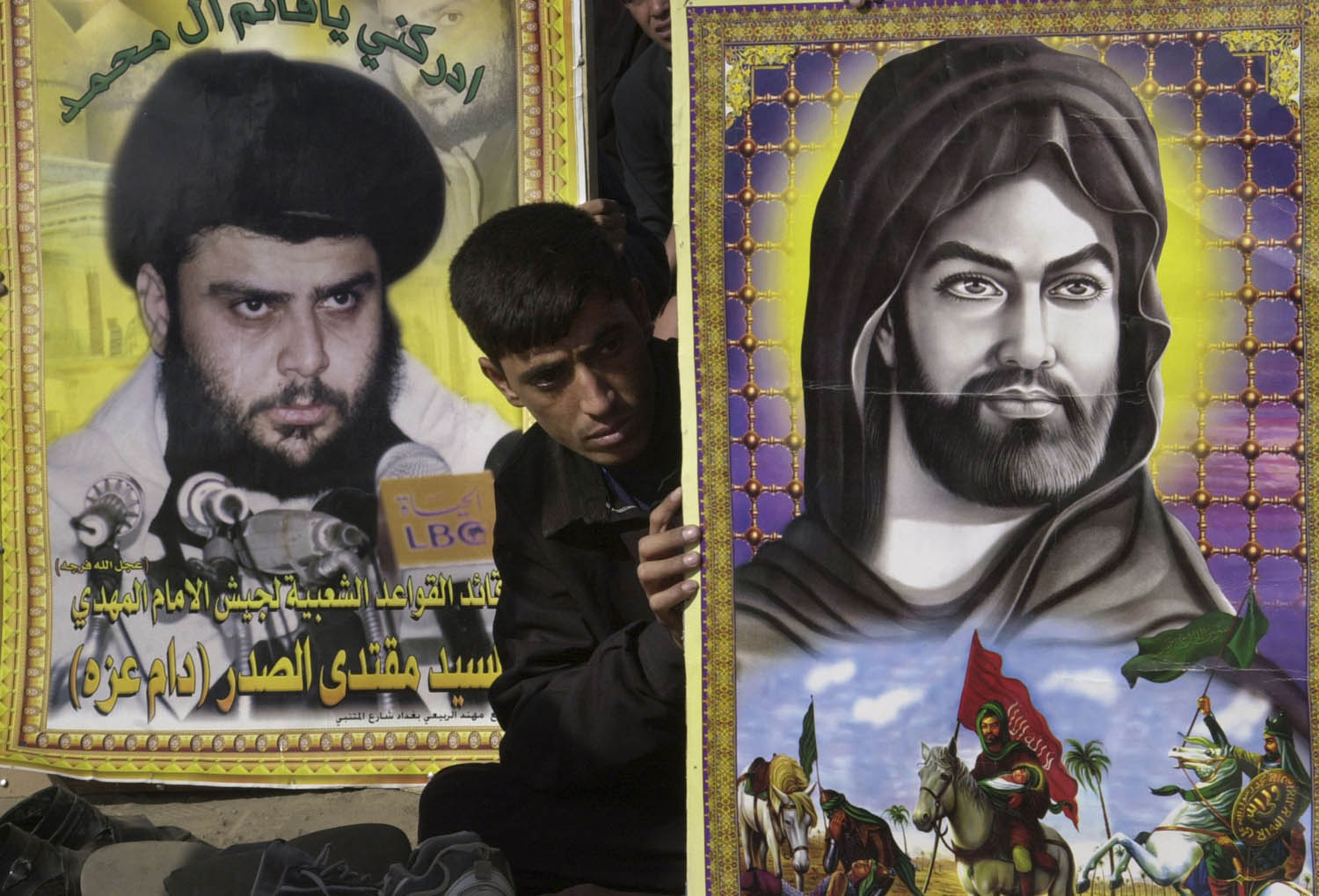 متظاهر من التيار الصدري يرفع صورة متخيلة للإمام الحسين وصورة لمقتدى الصدر