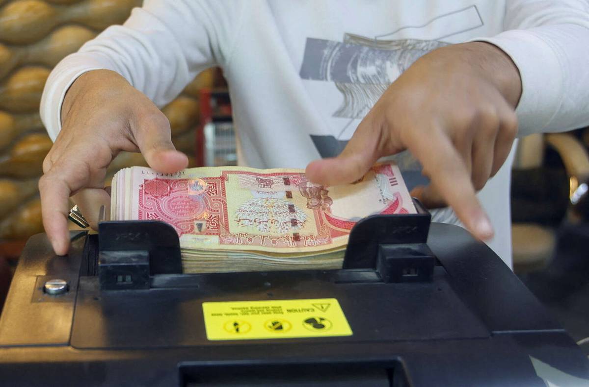 صراف عراقي وسط بغداد يعد الدنانير بماكنة آلية