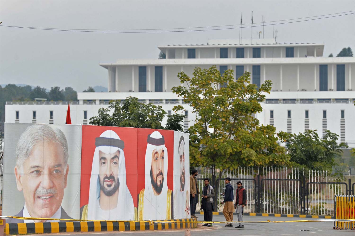 Workers arrange portraits of UAE President Sheikh Mohamed bin Zayed al-Nahyan (C) and Pakistan Prime Minister Nawaz Sharif (L) along the constitution avenue in Islamabad 