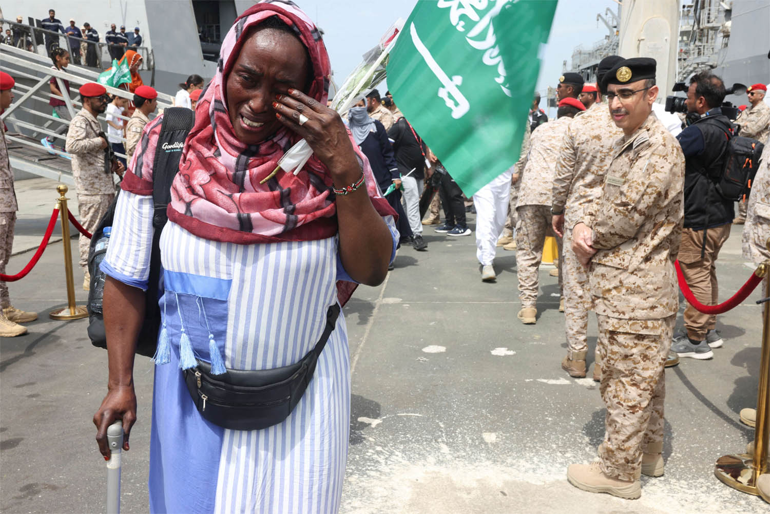 A Sudanese woman cries as she disembarks from Saudi Navy Ship with people from different nationality evacuated to Saudi Arabia from Sudan