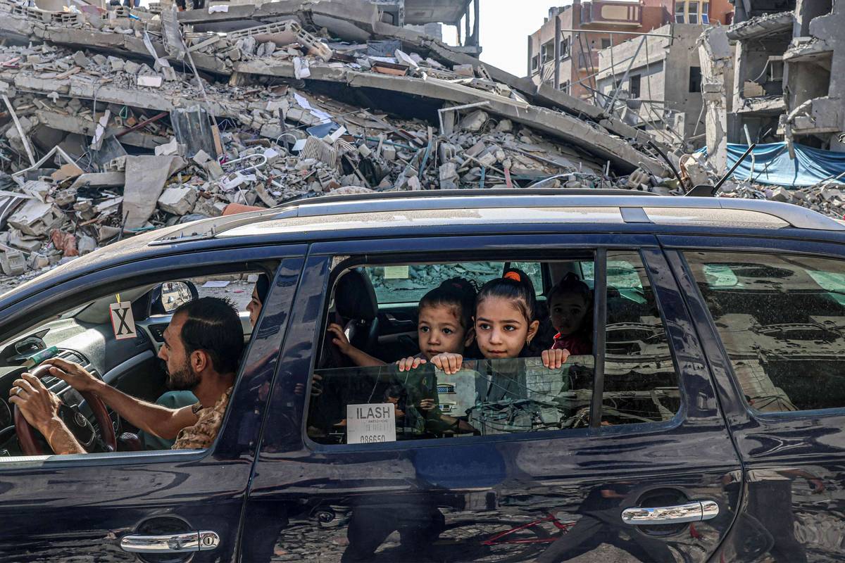 أطفال فلسطينيون في سيارة يغادرون مدينة غزة على خلفية دمار القصف الاسرائيلي