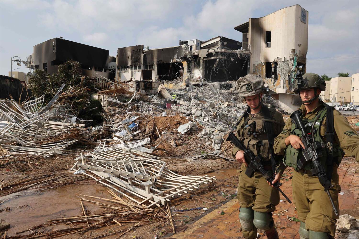 Soldiers walk in front of an Israeli police station that was damaged during battles to dislodge Hamas militants who were stationed inside