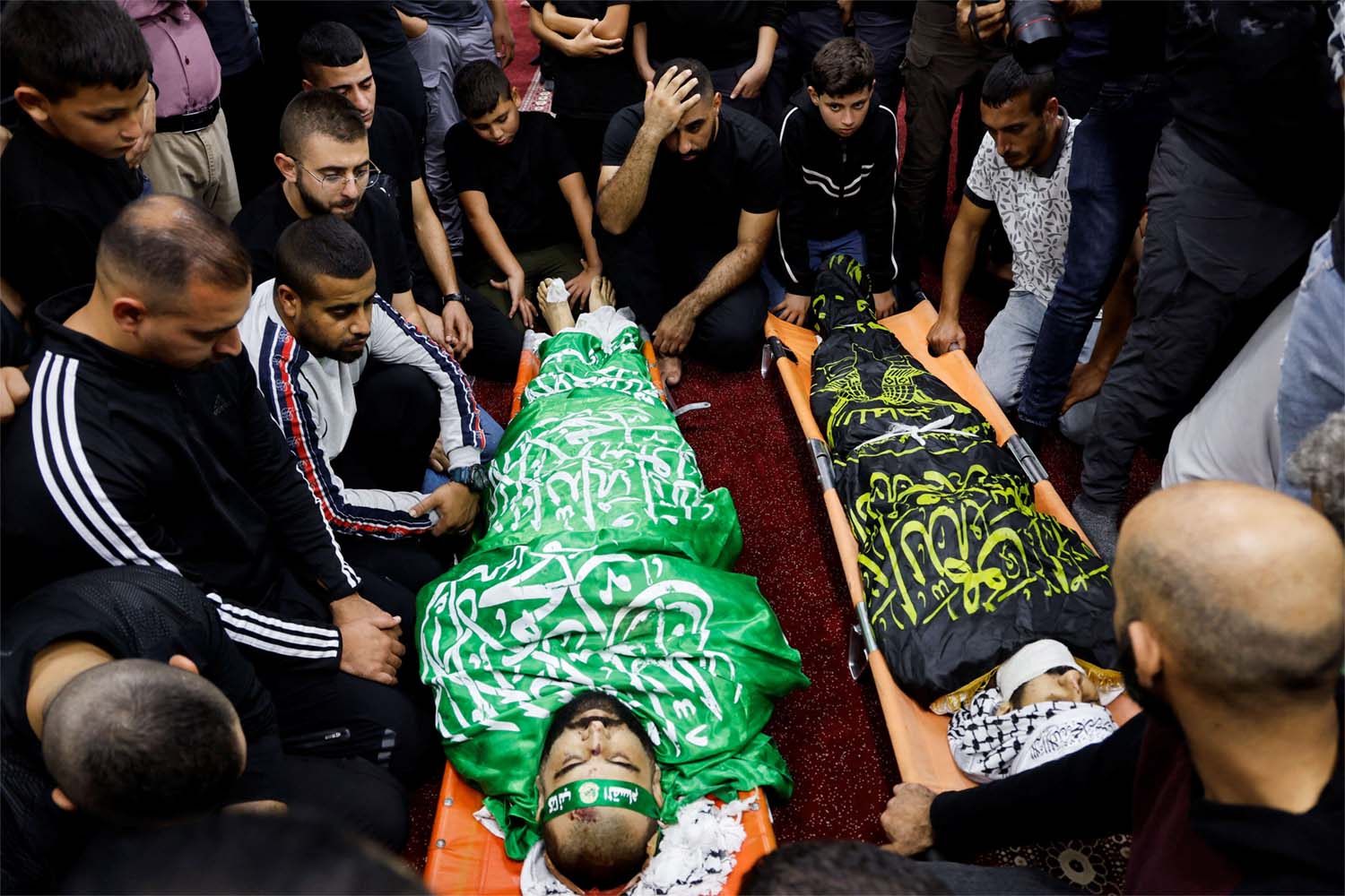 People attend a funeral for 3 Palestinians who were killed when Israeli forces raided Jenin refugee camp