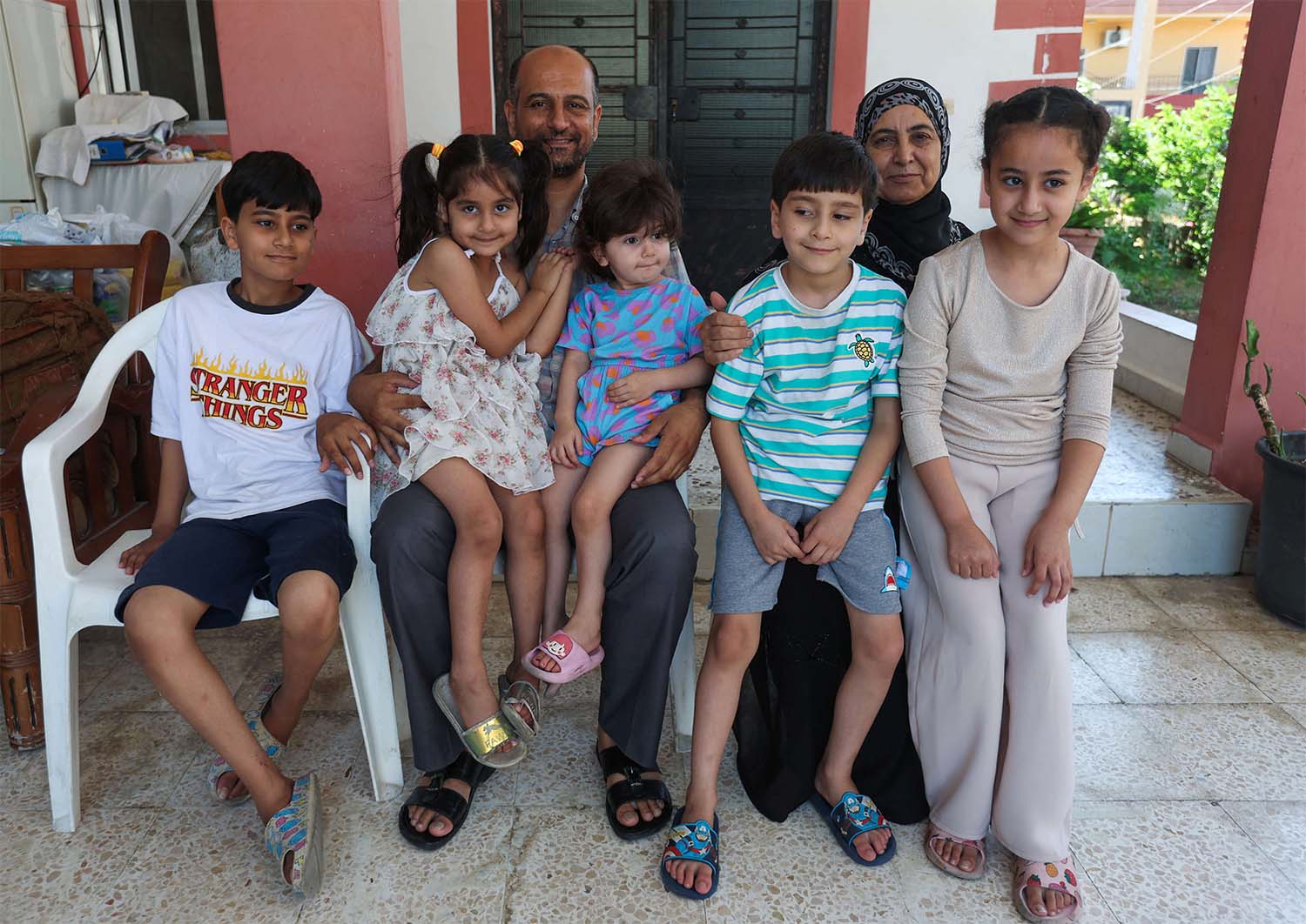 Samer Abu Della, displaced Lebanese from southern border village of Yarine, poses for a picture with his family