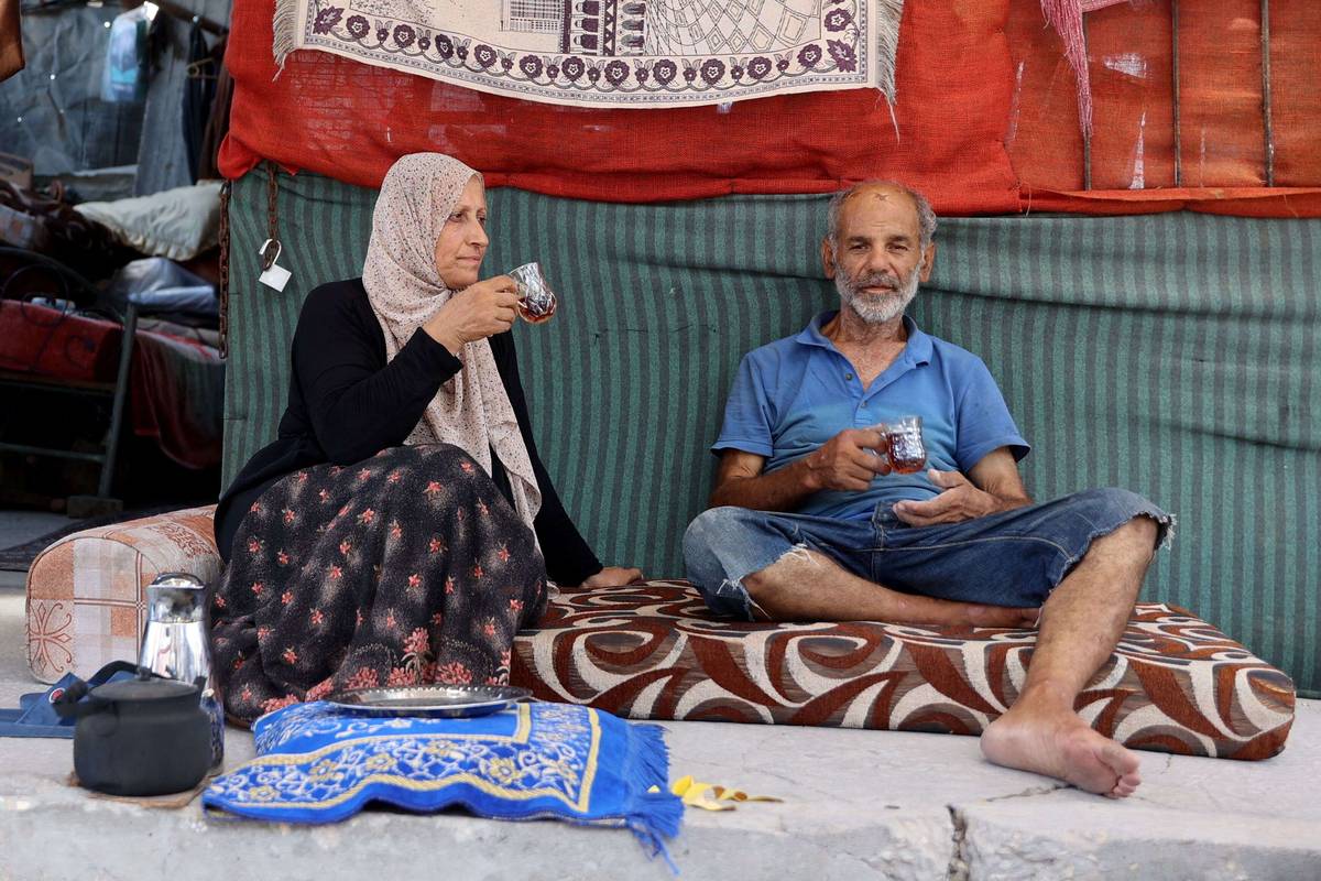 عائلة فلسطينية بالقرب من انقاض بيتها المهدم في غزة