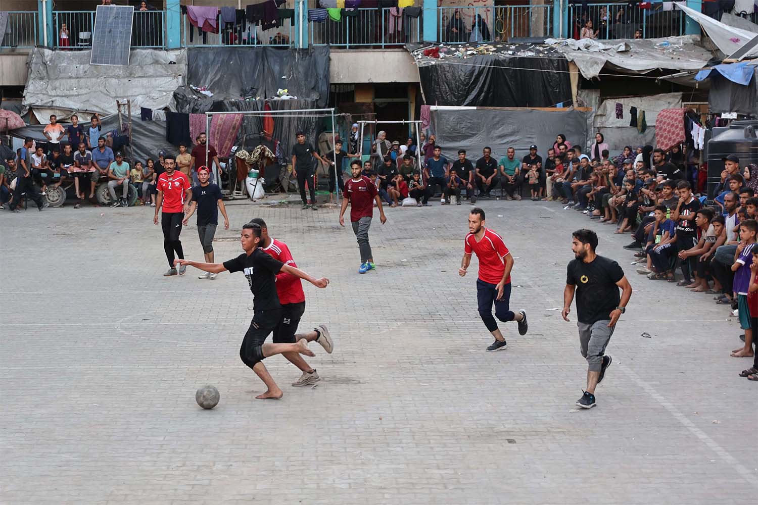 Playing football in the courtyard of a school-turned-shelter